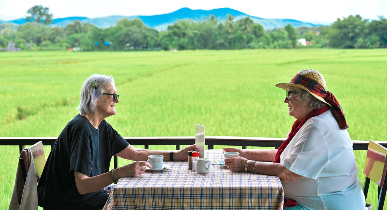 Senior residents enjoying coffee and conversation with countryside views at Vivobene Chiang Mai